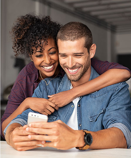 Smiling couple reviewing estate planning options on their phone