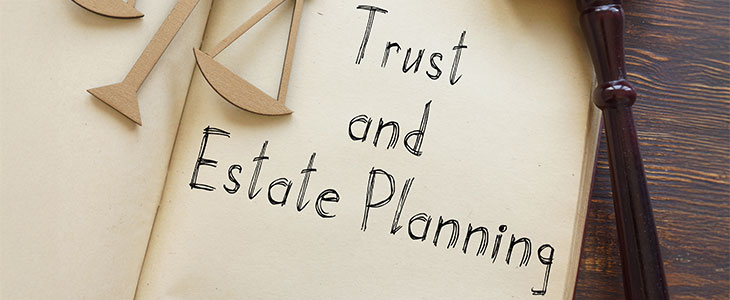 A gavel, scales of justice, and a document about trust and estate planning.