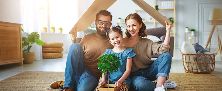 A smiling blended family sits under a cardboard roof, representing family and estate planning.